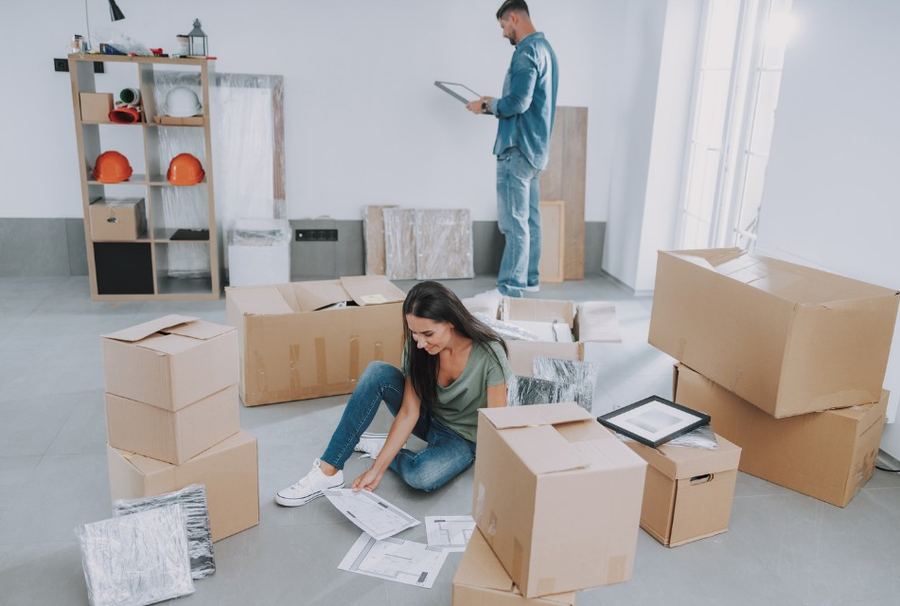Pareja clasificando cajas y documentos en una vivienda antes del vaciado — Cuánto cuesta vaciar un piso