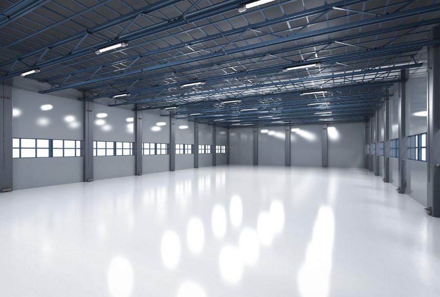 Nave industrial vacía con estructura metálica azul tras el vaciado — Vaciados Alicante: vaciamos pisos, casas y locales en 24–48 horas