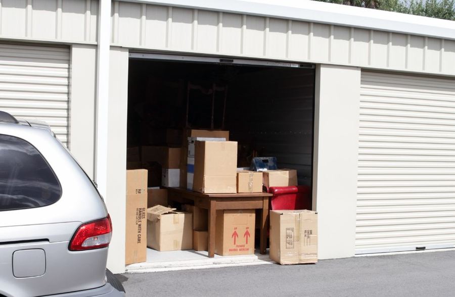 Trastero lleno de cajas y muebles con la persiana abierta, pendiente de vaciar — Multa por tirar muebles a la calle